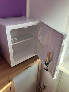 an empty refrigerator with a bottle of beer in it at 1 Privatzimmer möbliert gut ausgestattet und gute Anbindung Bus Bahn in Hohenbrunn +26 photos