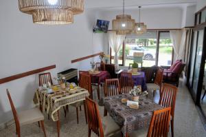 a dining room with tables and chairs and chandeliers at Hostal El Vendaval in Miramar