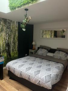 a bedroom with a large bed and a chandelier at Appartement centre ville Calais Ines in Calais