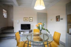 a dining room with a glass table and chairs at Dietro le campane in Arezzo