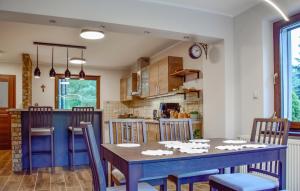 a kitchen and dining room with a blue table and chairs at 2 Bedroom Awesome Home In Gorzkie Pole in Wronczyn