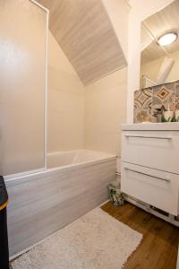 a bathroom with a tub and a shower at Appartement centre ville Calais Ines in Calais