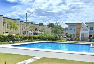a swimming pool in front of some apartment buildings at Cozy 4BR Diamond near Airport D'Arches Place in Davao City