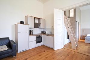 a small kitchen with a refrigerator and a staircase at Ferienwohnungen Herrenhaus Gut Oestergaard in Steinberg +29 photos