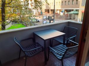 モンツァにあるMako Suites - Centro e Stazioneの窓のあるバルコニーにテーブルと椅子が置かれている