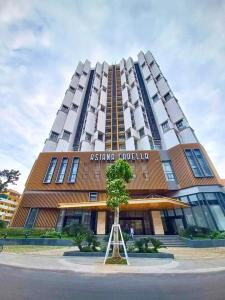 a tall building with a tree in front of it at Luxury Apartment Asiana Capella Trung tâm Chợ lớn in Ho Chi Minh City
