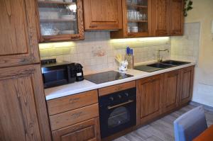 a kitchen with wooden cabinets and a sink and a microwave at Maison Belle Vue in Courmayeur