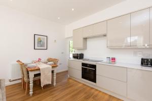 a kitchen with white cabinets and a table with chairs at The Lawley in Shrewsbury +71 photos
