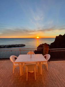a table and chairs on a balcony with a sunset at la Chiglia in Riomaggiore