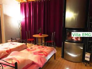two beds in a room with a table and purple curtains at Ferienhaus Event Haus EMG Hockenheim für Familien und Gruppen bis 22 Personen mit Partyraum in Hockenheim