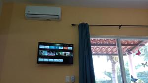 a flat screen tv on the wall next to a window at Manzanillo BNB in Manzanillo