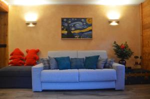 a living room with a blue couch and two stuffed animals at Maison Belle Vue in Courmayeur