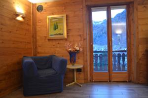 a room with a chair and a vase on a table at Maison Belle Vue in Courmayeur +35 photos