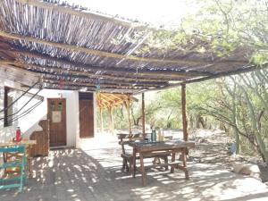 un patio con tavolo e sedie sotto un pergolato di Centro Ecoholístico Alami a San Marcos Sierra