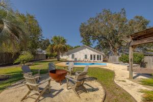 ein Hof mit Stühlen und einem Tisch und einem Pool in der Unterkunft Milly by the Sea in Saint Simons Island