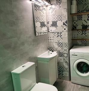 サンルーカル・デ・バラメダにあるApartamento Plaza del Cabildo - Sanlúcar Centroのバスルーム(トイレ、洗面台、洗濯機付) +2枚の写真