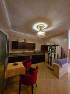 a kitchen with a table and red chairs and a ceiling at The Pearl of The Kasbah With a Terrace and breakfast-Entire House in Tangier