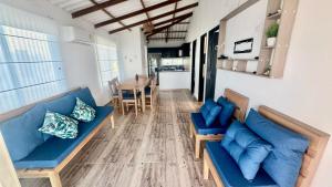 a living room with a blue couch and a table at Hermosa Cabaña Frente Al Mar in San Bernardo del Viento
