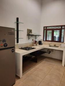 a kitchen with a stove and a refrigerator at Casa Mor - Surfhouse - 2 min from the beach in Santa Teresa Beach