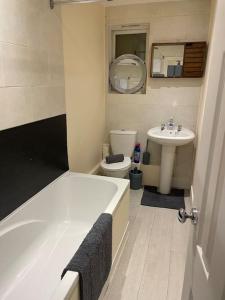 a bathroom with a tub and a toilet and a sink at Flat 3 Meadow View Cozy Getaway in Hurst