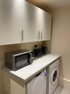 a kitchen with a microwave and a washing machine at Flat 3 Meadow View Cozy Getaway in Hurst +4 photos