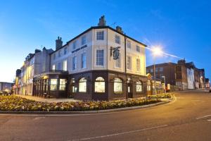 um grande edifício na esquina de uma rua em The Queen Hotel Wetherspoon em Aldershot