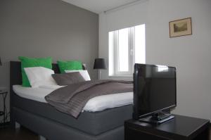 a bed room with a tv and a desk at Kunsthaus Apartments in Vienna