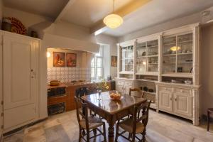 a kitchen with a wooden table and chairs and a dining room at 6 Roosevelt Str in Ermoupoli