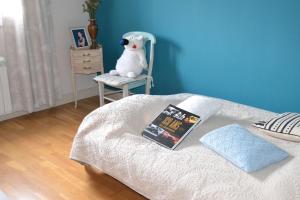 a bed with a book and a stuffed dog sitting on a chair at SAINT Pavace in Saint Pavace