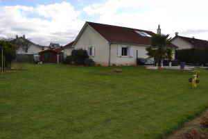 a yard with a white house and a green lawn at SAINT Pavace in Saint Pavace