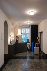 贝尔格莱德Pavilion Boutique Hotel的站在酒店大堂的男人和女人