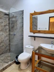 a bathroom with a toilet and a sink and a mirror at Casa Mor - Surfhouse - 2 min from the beach in Santa Teresa Beach
