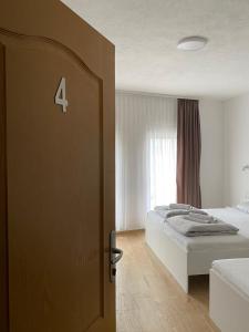 a bedroom with a bed and a door with the number four at Prenoćište Stari Grad - Old Town in Tuzla