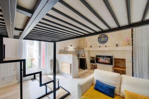 a living room with a couch and a clock at Appartement au Cœur de Tours in Tours +14 photos