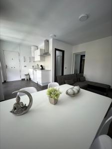 a white table with two vases on it in a living room at Apartamento Verdial 3 in Rincón de la Victoria