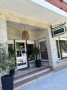 a building with potted plants in front of a store at Hostal El Vendaval in Miramar
