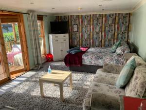 a bedroom with a bed and a couch and a table at Cosy Cabana Belfast in Belfast