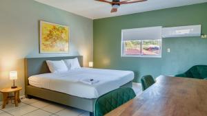a bedroom with a bed and a table and a window at Talk of the Town Inn & Suites - St Eustatius in Oranjestad