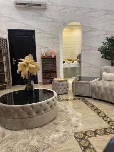 un salon avec un canapé et une table basse dans l'établissement فيلا عائلية مميزة بحوض سباحة ومرافق خاصة, à Ras al Khaimah