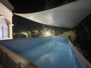 - une piscine dans une maison la nuit dans l'établissement فيلا عائلية مميزة بحوض سباحة ومرافق خاصة, à Ras al Khaimah