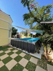 - une piscine dans une cour avec des chaises à côté d'une maison dans l'établissement فيلا عائلية مميزة بحوض سباحة ومرافق خاصة, à Ras al Khaimah