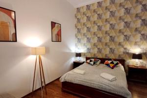 1 dormitorio con 1 cama, 2 lámparas y una pared en Cozy Old Town Apartments, en Cracovia 138 fotos más