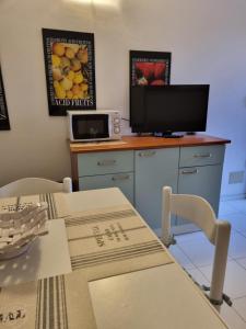 ポルト・アッズッロにあるLa casina di Adinaのキッチン(テーブル、カウンター内のテレビ付)