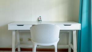 ein weißer Schreibtisch mit einem weißen Stuhl und ein Tisch mit einem weißen Stuhl in der Unterkunft Talk of the Town Inn & Suites - St Eustatius in Oranjestad