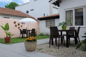 a patio with a table and chairs and an umbrella at Hostal El Vendaval in Miramar +29 photos
