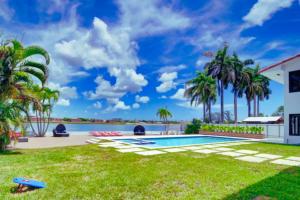 a backyard with a swimming pool and palm trees at Club House 305 w PRIVATE NIGHTCLUB, Cinema, Game Room, Gym & Pool in Miami