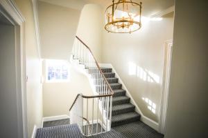 eine Treppe mit einem Kronleuchter in einem Haus in der Unterkunft The Lazy Goose - Coffee House & Bedrooms in Stonehouse + 5 Fotos