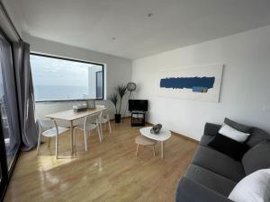 a living room with a couch and a table at Sky T2, Vista Mar e Piscina em Varadouro, Faial in Capelo