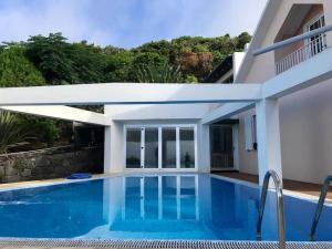 a swimming pool in front of a house at Sky T2, Vista Mar e Piscina em Varadouro, Faial in Capelo