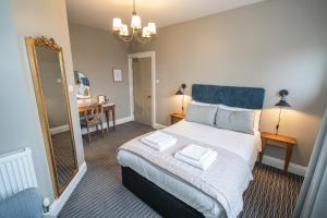 Schlafzimmer mit einem Kingsize-Bett und einem Spiegel in der Unterkunft The Lazy Goose - Coffee House & Bedrooms in Stonehouse